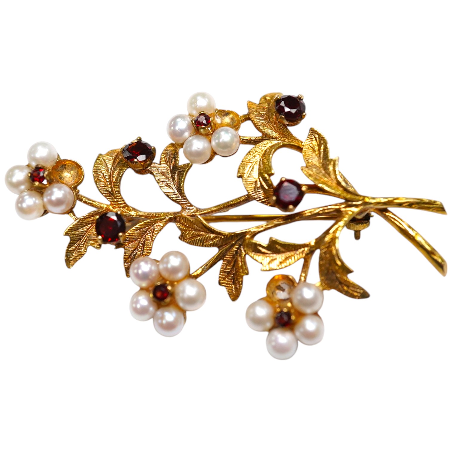 A 1960's 9ct gold, cultured pearl and garnet cluster set foliate spray brooch, 52mm (three pearls missing), gross weight 9.3 grams. Condition - poor